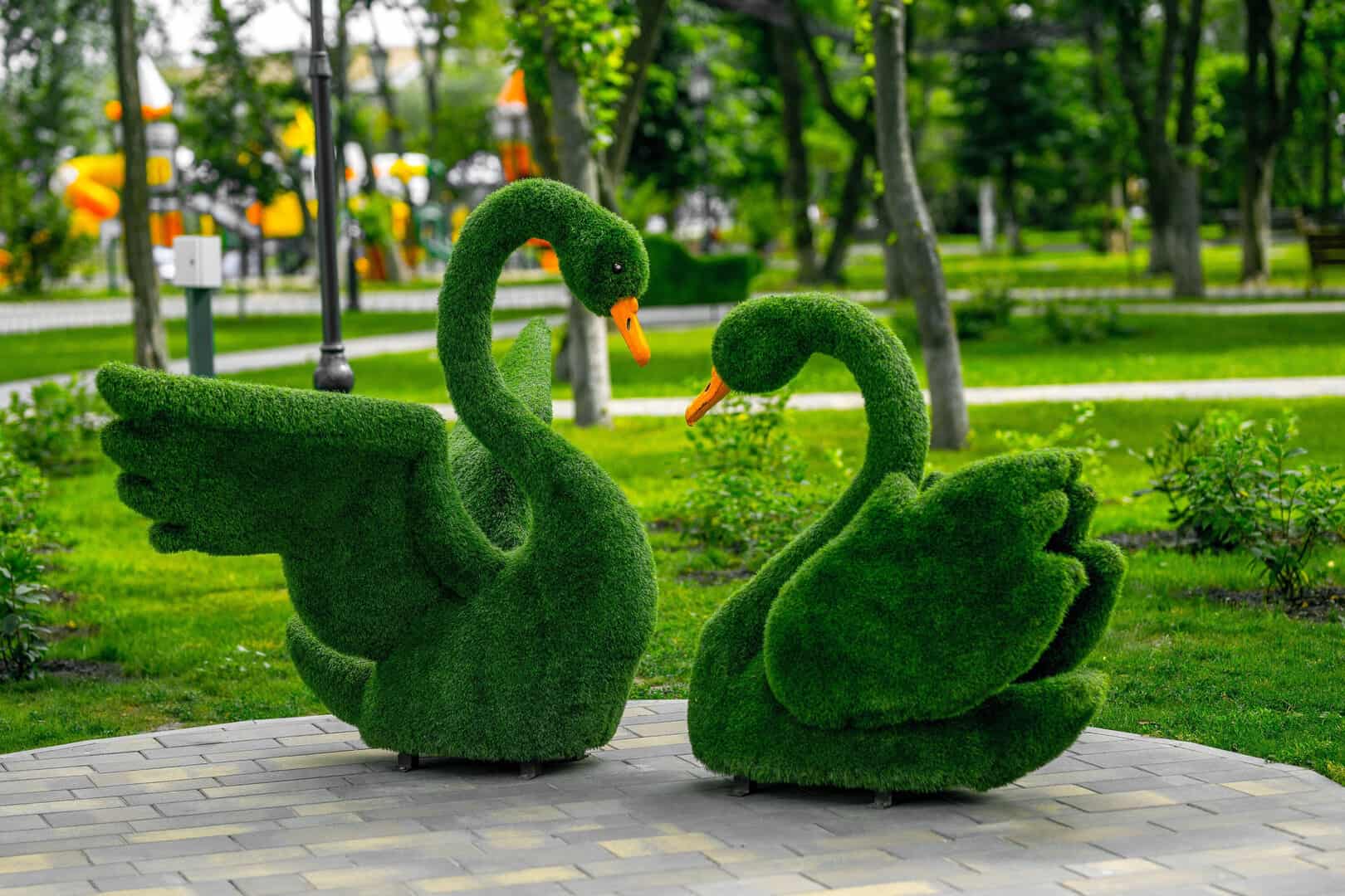 See description Sculpture of a pair of swans made of artificial grass